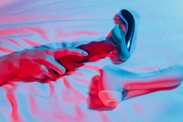 Woman in bedroom holding vibrator in hand.
