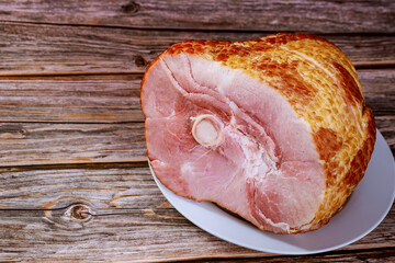 Sliced honey smoked ham on wooden table.