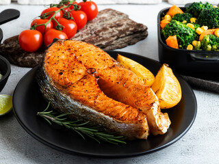 roast baked fish steak salmon, trout with broccoli and carrots, on plate