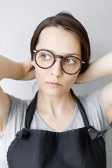 soft selective focus, portrait of a young and beautiful caucasian woman with dark hair who will put her hair back. hairstyle, home look, glasses, brooding look