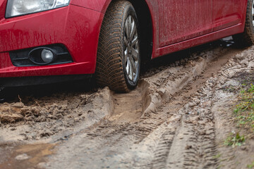 Car stuck in the mud, car wheel in dirty puddle, rough terrain