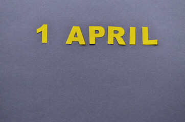 Date April 1 is laid out of paper letters yellow on a gray background with copy space. High quality photo