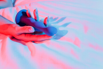 Woman holding anal balls in bed close-up.