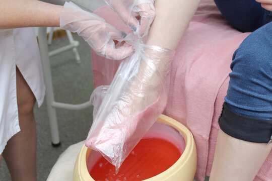 woman foot treatment in paraffin bath at the spa.
