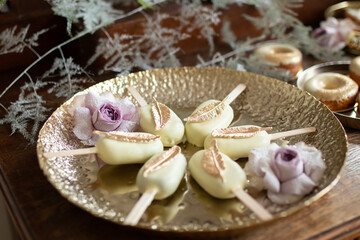 A closeup of a dessert in the shape of ice cream on a golden plate