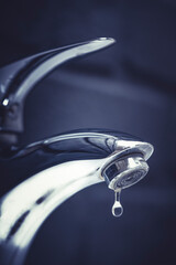 water drop dripping from the tap and water shortage	