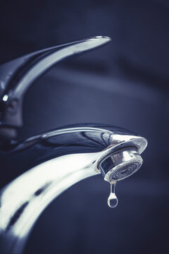 water drop dripping from the tap and water shortage	