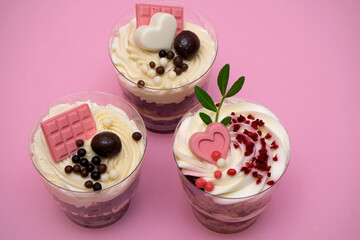 Sweet small homemade trifle dessert with custard, chocolate, nuts and fruits and decorations and cream cheese.