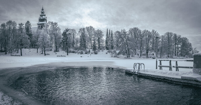 Panoramic image of winter swimming place in Naantali, Finland. The beautiful white stone Naantali church is in the background which is the second oldest medieval stone church in Finland.