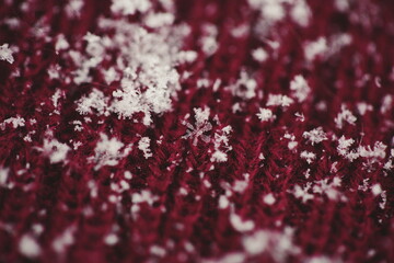 Detailed up-close macro image of snowflakes on knitted fabric.