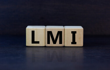 LMI, lenders mortgage insurance symbol. Wooden cubes form the word 'LMI, lenders mortgage insurance'. Beautiful grey background, copy space. Business and LMI, lenders mortgage insurance concept.