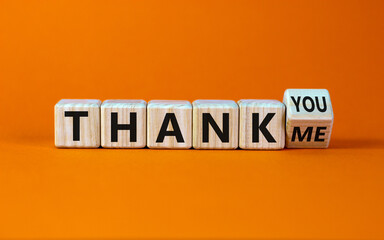 Thank you or me symbol. Turned a cube and changed words 'thank me' to 'thank you'. Beautiful orange background, copy space. Business, psychology and thank you or me concept.
