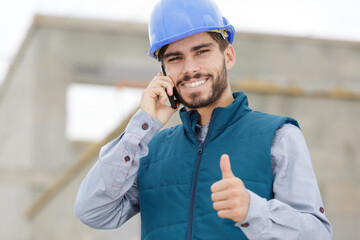 handsome builder showing thumbs up and laughing