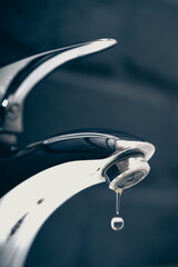 water drop dripping from the tap and water shortage	