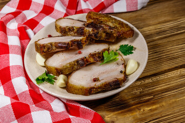 Baked pork belly in a plate on wooden table