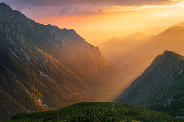 Golden sunset with sunbeams in big mountain landscape
