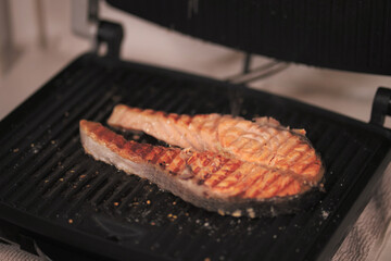 cooking red fish in a pan. healthy sea food full of omega fat.