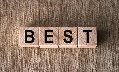 BEST word written on wooden blocks on a brown background.