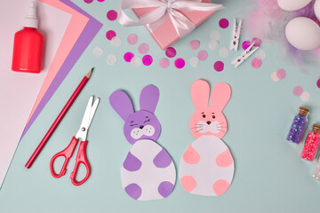 Fototapeta premium Step-by-step instructions. Easter bunnies. Step 5 The postcard is ready. DIY. Flat lay. Making an Easter card.