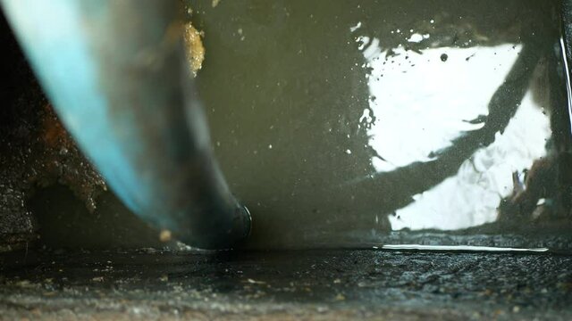 Septic cesspool emptying pumping into pipe tank by suction hose under high pressure. The sump contains pollution sludge sewage water black wastewater and faeces plus excrements from home