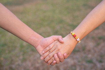 Couple holding hands with hand string of LOVE word in blur background, Happy Women's, Mother's, Valentine's Day concept.