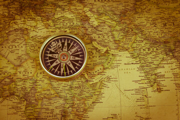 Fototapeta na wymiar Compass on a vintage world map. Retro style