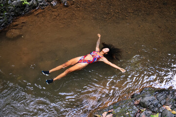 Woman relaxing in a waterfall in Costa Rica.
