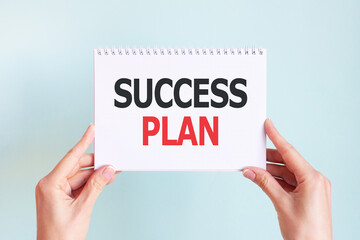 SUCCESS PLAN word inscription on white card paper sheet in hands of a woman. Business concept
