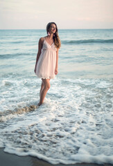 Fototapeta na wymiar Young slim beautiful woman on sunset beach