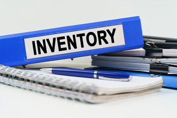 On the table are a notebook, a pen, documents and a folder with the inscription - INVENTORY
