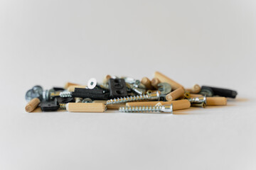 On a white background lies a group of building materials - screws, screws and others.
