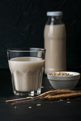 Vegetable oat milk in glass and bottle on table