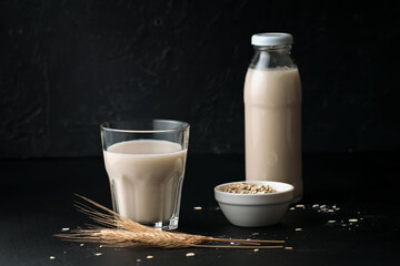 Vegetable oat milk in glass and bottle on table