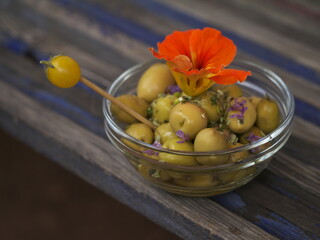 Ein Schälchen dekorierte Oliven auf einem Gartentisch