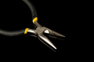 Diagonal pliers close-up on a black background are commonly used to repair electricity