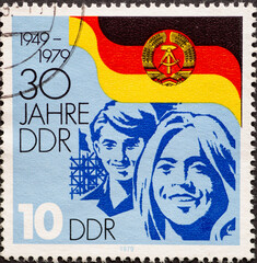 GERMANY, DDR - CIRCA 1979 : a postage stamp from Germany, GDR showing Faces of young people in front of the flag of the GDR: 30 years of the GDR
