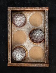 Jelly filled doughnuts with powdered sugar in a box