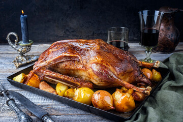 Traditional roasted stuffed Christmas goose with quinces and orange slices served as close-up on an...