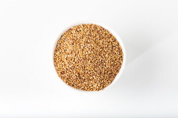 Bowl of sesame seeds on the white background.