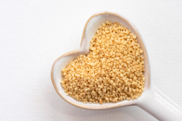 Uncooked Couscous on a Heart Shaped Spoon