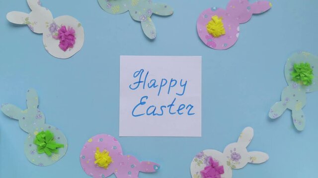 Happy easter note appear. Close-up ester template with bunnies on blue background. 