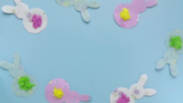 Happy easter note. Close-up ester template with bunnies on blue blurred background. Woman hand.