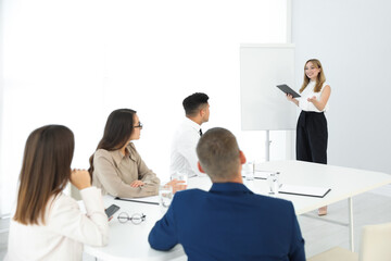 Naklejka na ściany i meble Female business coach talking to audience in office