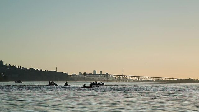 Kayaks and other watercraft on the water with Vancouver in the background at sunset. HD 24FPS.