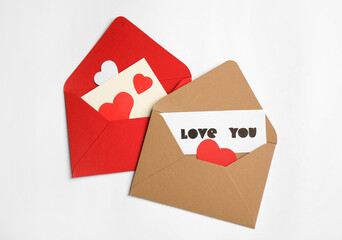 Card with phrase Love You, envelopes and paper hearts on white background, flat lay