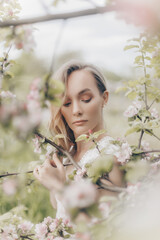 girl in a white dress walks in an apple orchard