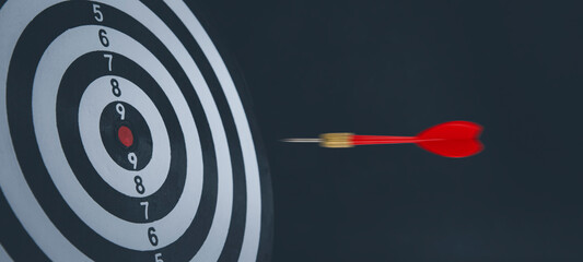 Close up shot of the dart arrow hit on bullseye, red dart arrow hitting in the target center of...