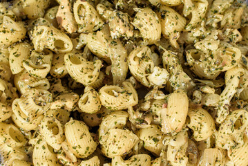 Detail of a gomiti pasta dish prepared with pesto sauce.
