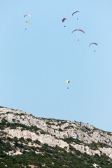 Fototapeta na wymiar Paragliders over the mountains, Parque Natural da Arrábida, Setúbal, Portugal