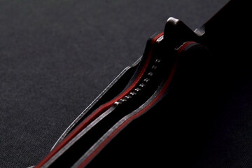 frame-lock of folding knife on black background